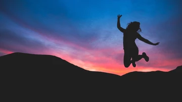 girl jump under sunset