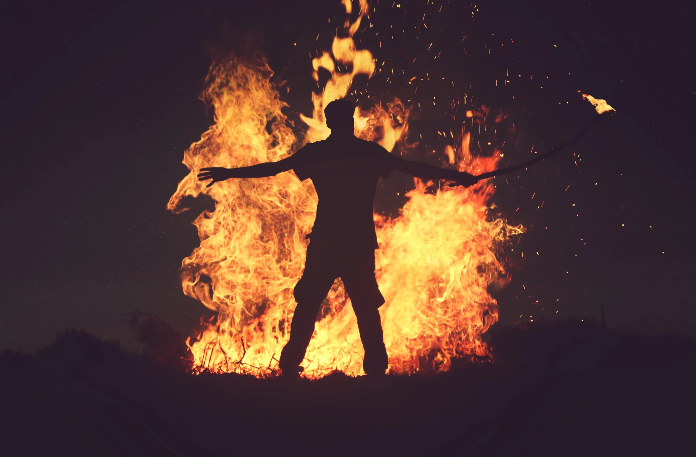 man in front of the bon fire